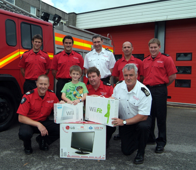 Firefighters from Orange watch at Truro Community Fire Station pictured with Joshua and his prize