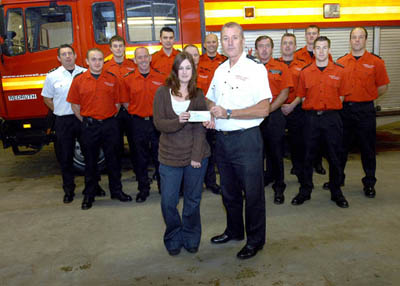 Divisional Commander - Mark Boeck accepting the cheque on behalf of the charity from Mrs Gay, alongside Malcolm